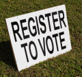 Image of a sign saying "Register to Vote" in the grass