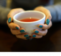 Image of person holding a cup of warm drink