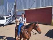 Mounted Posse member displaying the flag