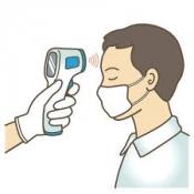 Person in white mask having forehead scanned by thermometer